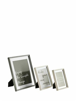 Drei stehende Fotorahmen mit motivierenden Botschaften: "Enjoy the simple things," "Make your own magic," und "Darling you're different."