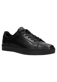 Sneaker in pelle nera con punta arrotondata, occhielli in metallo e lacci piatti. Presenta una suola in gomma nera testurizzata con dettagli orizzontali.