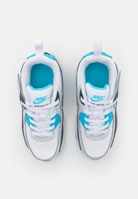 Sneaker Nike Air Max bianchi e grigi con accenti turchesi, dotati di linguetta in rete, lacci e un logo prominente sul tallone.