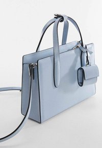 Bolso de mano de cuero azul claro con acentos negros, forma rectangular, doble asa, correa desmontable y un pequeño bolsillo frontal.