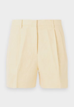 Shorts beige taille haute, cintrés avec plis, passants pour ceinture, et une fermeture éclair à l'avant, sur un fond clair.