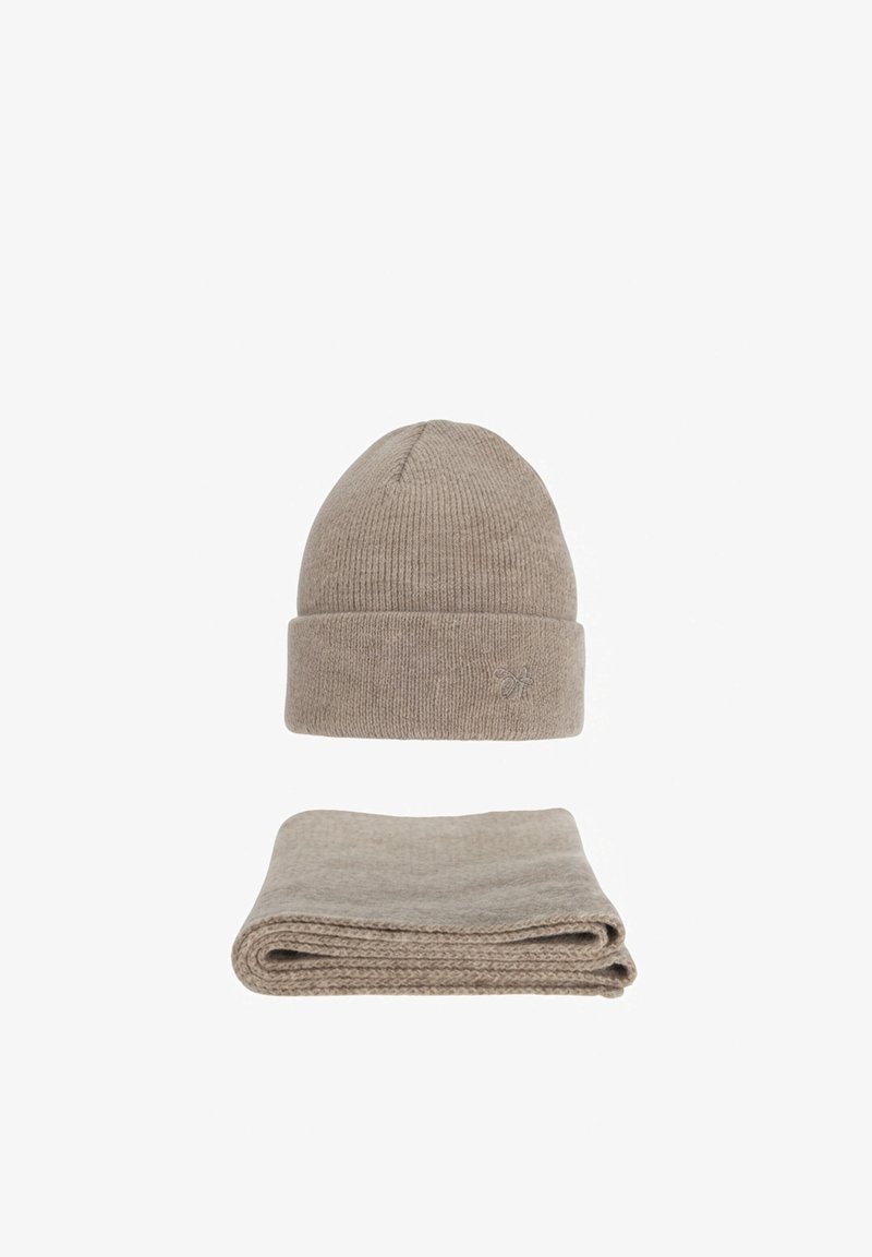 Bonnet d'hiver en maille beige avec petit logo brodé au-dessus d'une écharpe assortie beige en maille pliée, sur fond blanc.