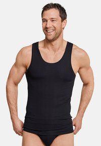 Zwarte geribbelde tanktop van rekbare stof, met brede schouderbanden en een aansluitend ontwerp. De textuur is soepel met subtiele verticale lijnen.