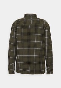 Camicia a flanella a scacchi verdi con maniche lunghe, caratterizzata da un motivo a reticolo bianco e nero, polsini con bottone e colletto classico.