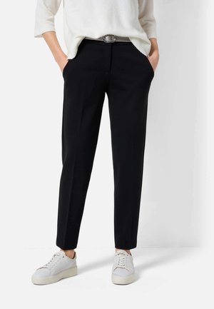 Zwarte op maat gemaakte broek met een gladde textuur, voorzien van zijzakken en een klassieke snit, gecombineerd met witte sneakers.