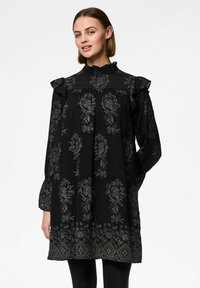 Černé šaty s květinovým vzorem, volány na ramenou, vysoký límec, sklady v přední části a dlouhé rukávy. Mají vzorovaný lem.