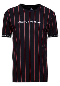 Czarna koszulka z pionowymi czerwonymi paskami. Ma okrągły dekolt i krótkie rękawy. Logo "Kings Will Dream" nadrukowane na białym tle na klatce piersiowej i rękawach.