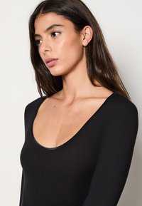 Svart långärmad bodysuit med bred rundad halsringning och en åtsittande design, tillverkad av mjukt, stretchigt tyg.
