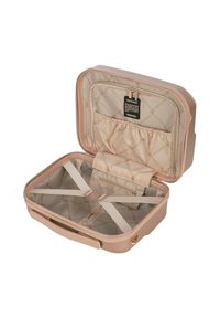 Harde koffers in lichtroze, met een crèmekleurig interieur met een herhalend logo-patroon en kruisbanden voor compartimentering.