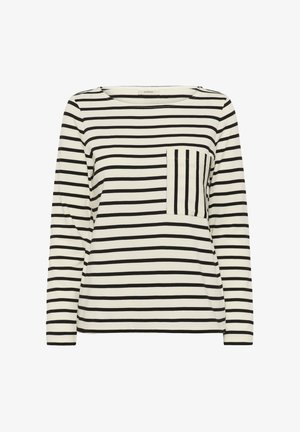 Krémová košeľa s dlhým rukávom s čiernymi horizontálnymi pruhmi a náprsným vreckom so zvislými čiernymi pruhmi.