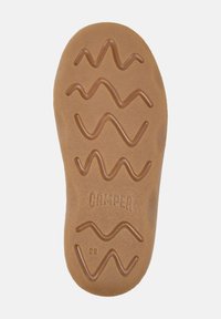 Suela de zapato de goma marrón con patrón de tracción ondulado y texto "CAMPE". Presenta una forma redondeada y una textura sutil para mayor agarre y durabilidad.