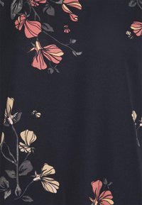 Tela azul marino con un patrón floral en tonos rosa y crema. Presenta pétalos y hojas detallados, creando una apariencia texturada.