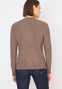 Brauner gestrickter Pullover mit langen Ärmeln, strukturiertem Stoff und geripptem Saum. Verfügt über einen schlichten Rundhalsausschnitt und eine taillierte Silhouette.