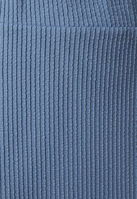 Tissu côtelé bleu avec des rayures verticales. La texture semble douce et extensible, adaptée aux vêtements ajustés. Pas de motifs ou de matériel notables.