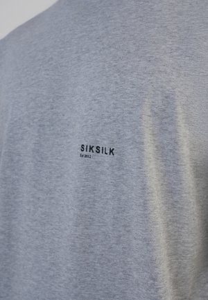 Sivá tričko vyrobené z bavlnenej látky. Na zadnej strane obsahuje čierne potlačené logo s textom "SIKSILK" a "Est 2012" umiestnené horizontálne. Jednoduchý dizajn, krátke rukávy.