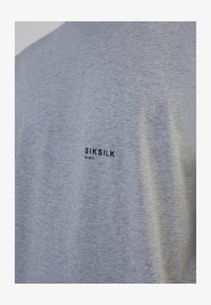 T-shirt grigia in cotone. Presenta un logo stampato nero con "SIKSILK" e "Est 2012" in orizzontale sulla schiena. Design semplice, maniche corte.