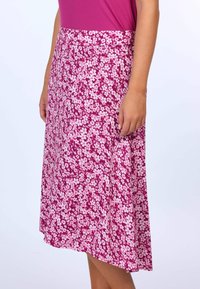 Rosa geblümter Rock mit fließendem Design, knielang, mit einem Muster aus weißen und hellrosanen Blüten auf einem satten rosafarbenen Hintergrund.