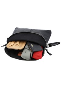 Borsa nera di pelle con cerniera argentata, contenente utensili in legno, un sacchetto verde, un oggetto rosso e un portafoglio nero testurizzato.