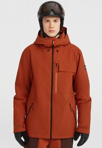 Skijack in feloranje, gemaakt van waterdicht materiaal. Bevat een verstelbare capuchon, ritszakken en zwarte handschoenen, met een ontspannen pasvorm.