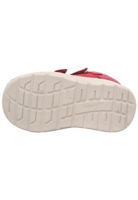 Die rosa Schuhsohle eines Kindes mit strukturiertem Profilmuster, Größe 20, und dem eingeprägten Markennamen "superfit" auf der Unterseite.