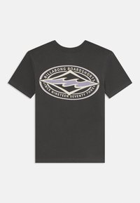 Camiseta de algodón gris con un gran gráfico ovalado que presenta olas, "Billabong Boardshorts" y "Desde mil novecientos setenta y tres" estampado en crema y púrpura.