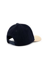 Marineblauwe pet met een beige klep, gemaakt van stof. Kenmerkt zich door contrasterende witte stiksels en een verstelbare snapback sluiting aan de achterkant.