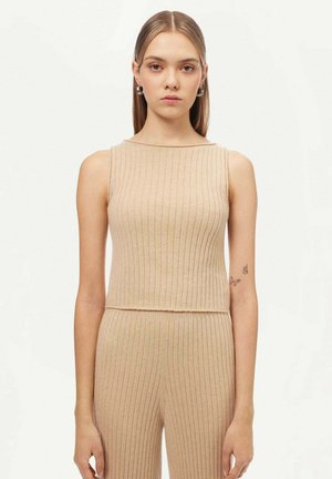 Beige geripptes Strick-Top mit gerade geschnittenem Ausschnitt und figurnahen Design. Der Stoff hat eine weiche Textur und ist zusätzlich kurz geschnitten.
