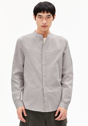 Graues Langarmshirt mit Stehkragen, Vorderknopfverschluss und dezentem Muster. Mit kleinem Logo auf der Brust.