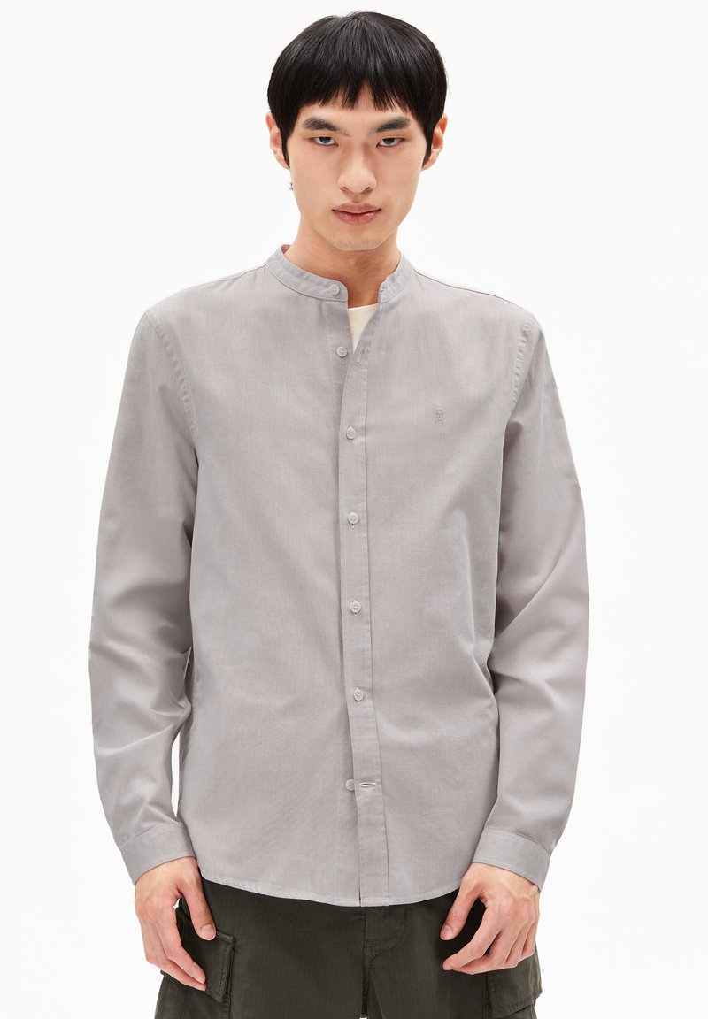 Grijze langslavende shirt met een Mandarin-kraag, voorzijde met knoopsluiting en subtiele textuur. Bevat een klein logo op de borst.
