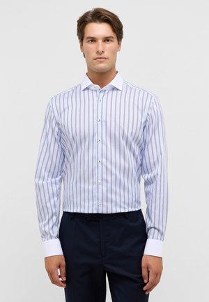 Weißes Button-up-Hemd mit vertikalen Marineblauen Streifen, langen Ärmeln, kontrastierendem Kragen und Manschetten; der Stoff wirkt glatt und hat eine taillierte Passform.