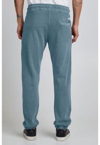 Lyseblå sweatpants med snoretræk i taljen, elastiske manchetter og en baglomme, lavet af blødt, struktureret bomuldsstof.