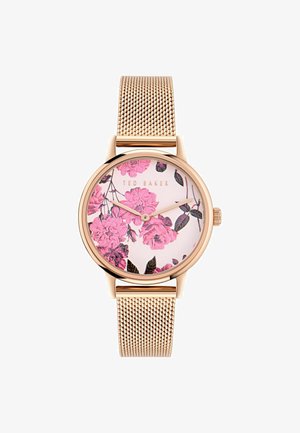 Ronde klok met een rosegouden meshband. Klok met bloemmotief met roze bloemen op een lichte achtergrond. Merkennaam weergegeven.