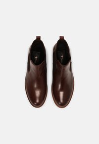 Bruna läderankelstövlar med elastiska sidopaneler och dragflikar. Smidig design, rund tå och strukturerad sula. Storlek 37.