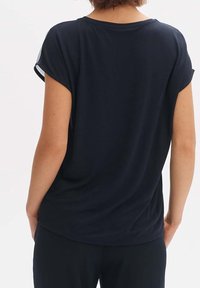 Marinblå t-shirt med korta ärmar, rund halsringning och lös passform. Slätt tyg och enkel fåll; inga synliga mönster eller logotyper.