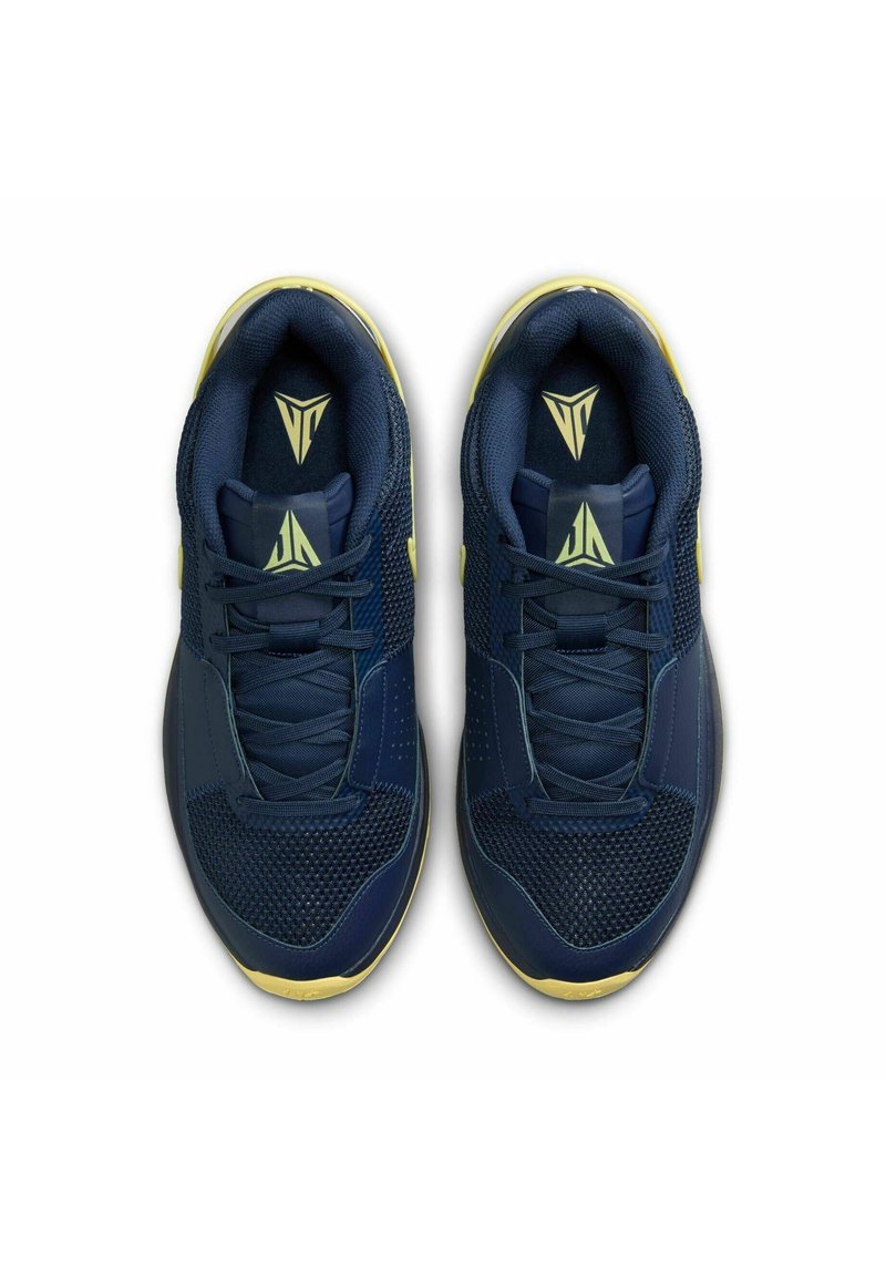 Granatowe buty sportowe z siateczki i materiału syntetycznego, z żółtymi akcentami, płaskimi sznurówkami i teksturowaną podeszwą dla lepszej przyczepności.