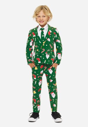 Grüner Anzug mit festlichen Mustern, der Weihnachtsmann-Gesichter, Zuckerstangen und Ornamente zeigt. Inklusive eines weißen Hemdes und einer Krawatte, abgerundet mit schwarzen Turnschuhen.
