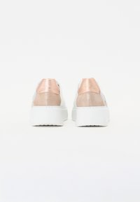 Vita sneakers med metallisk roséguld-accenter. Har en texturerad häl och släta sidor. Tjock vit sula ger upphöjt stöd.