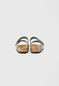 Sandali blu con doppie cinghie regolabili, sottopiede in sughero e suola in gomma. Presentano una texture sottile con minimi dettagli in metallo.