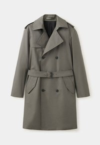 Trench-coat vert olive à double boutonnage avec ceinture, larges revers, épaulettes et poches à rabat, présenté sur fond blanc.