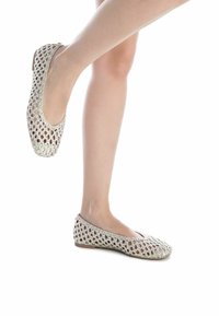 Ballet flats di colore chiaro, intrecciate, con un design aperto e arioso e una suola piatta. La superficie testurizzata presenta un motivo a diamante e una leggera lucentezza.