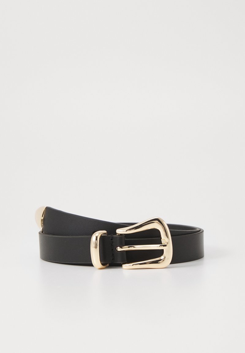 Ceinture en cuir noir avec boucle métallique dorée brillante et embout doré, enroulée sur une surface blanche avec un fond blanc uni.