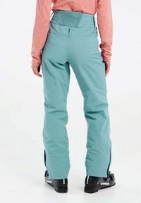 Aqua blauwe snowboardbroek met een hoge elastische tailleband, ritssluitingen bij de enkels en een strakke, gladde stoftextuur.