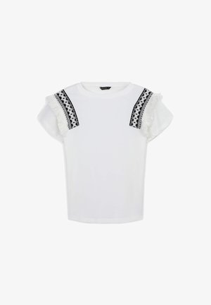 T-shirt blanc à manches courtes, avec des bordures noires à motifs et des franges blanches sur les épaules. Tissu doux avec une coupe décontractée.
