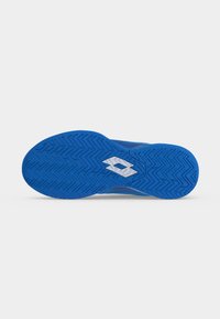 Blaue Sportschuhsohle mit Zickzack-Profil und weißem, diamantförmigem Logo in der Mitte auf schlichtem Hintergrund.