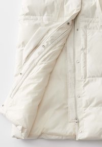 Leichte Fleece-Puffermantel mit durchgehendem Reißverschluss, Druckknöpfen und gesteppten Details. Das Innere ist glatt und hat keine sichtbaren Muster.