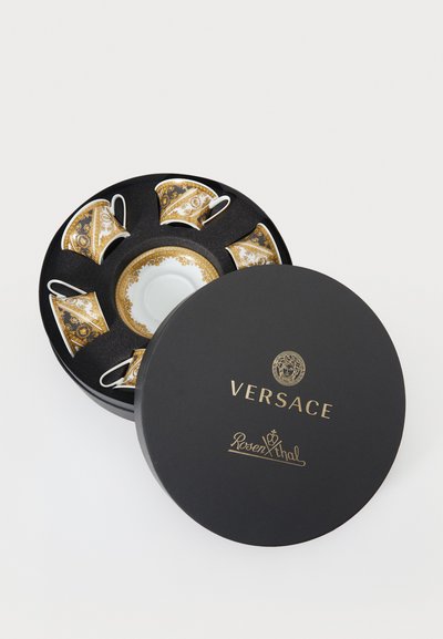 Set of four porcelain espresso cups and one saucer, featuring a gold pattern, presented in a black box with gold text.