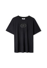 Camiseta de algodón negra con mangas cortas, que presenta un parche ovalado central con diseño bordado. Cuello redondo, corte relajado.
