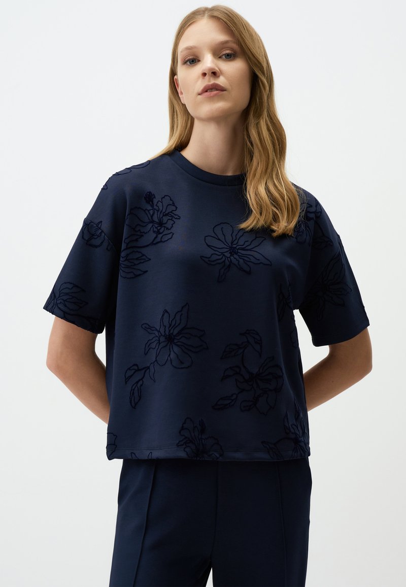 Navyblauwe, korte mouwen top met een gestructureerd bloemendessin. Gladde stof met een rond decolleté en een ontspannen pasvorm.