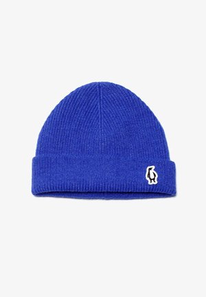 Berretto lavorato a maglia blu con risvolto, realizzato in materiale morbido; presenta un piccolo patch con logo di un pinguino bianco e nero sul lato.