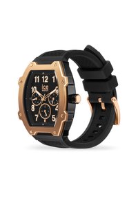 Orologio nero con una lunetta ottagonale in tono oro, un quadrante nero con texture, grandi numeri bianchi e un cinturino in silicone nero. Presenta sottodial e una chiusura in metallo.